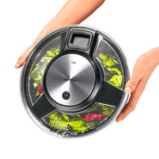 Über Öffnungen im Deckel können Sie das Wasser sauber abgießssen, ohne die Schleuder zu öffnen. Zwei Hände halten geöffnete Salatschleuder