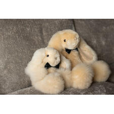 Jeder Hase ist ein handgefertigtes Unikat – Form und Farbe können leicht variieren. Zwei Alpaka-Hasen in champagnerfarben, auf einer Couch sitzend.