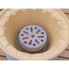 Details des Bratfeuers mit glühendem Grillstein im Inneren.