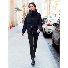 Navy Frau in schwarzer Jacke und Hose mit Schlupf-Boots auf der Straße.