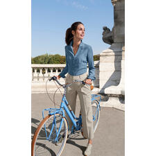 Offwhite Frau in denim Bluse und hellen Hosen mit Fahrrad im Freien.
