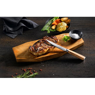 Damast-Steakmesser auf Holzbrett mit gegrilltem Steak und Gemüse.