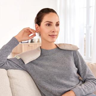 Frau trägt Schulterwärmer und sitzt entspannt auf der Couch