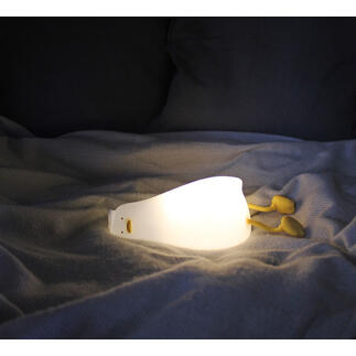 Müde Ente Nachtlicht leuchtet auf einem Bett.