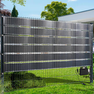 Solarkraftwerk eingezäunt mit mehreren Solarpanelen im Garten.