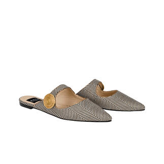 Zwei spitze Mules in Schwarz/Weiß mit dekorativem Detail.