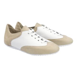 Beige und weiße Komfort-Sneaker auf einem neutralen Hintergrund, frontal betrachtet.