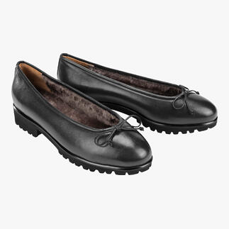 Zwei schwarz Lammfell-Ballerinas nebeneinander auf hellem Hintergrund.