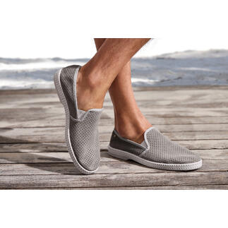 Grau Lederslipper mit perforierter Oberfläche auf Holzterrasse.