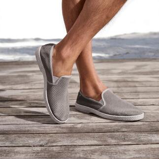 Grau Lederslipper mit perforierter Oberfläche auf Holzterrasse.
