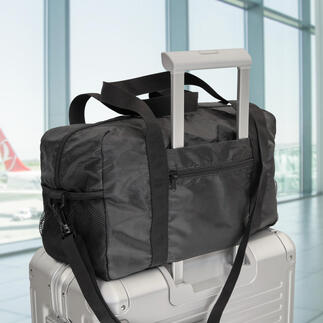 Exklusive faltbare Reisetasche auf einem Koffer im Flughafen.