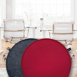 Zwei ultraflache Sitzkissen in verschiedenen Farben auf einem modernen Bürotisch.