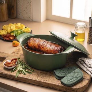 Ultraleicht-Bräter mit saftigem Braten, Kräutern und Beilagen auf einem Holzbrett.