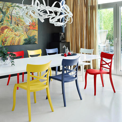 Bunte Design-Stühle um einen weißen Esstisch