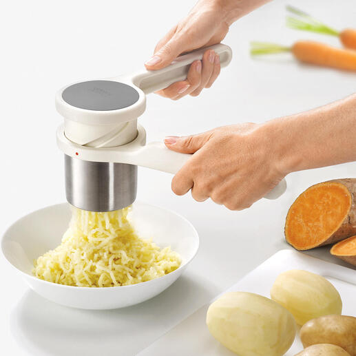 Hände verwenden Kartoffelpresse Helix™ zum Zerkleinern von Kartoffeln.