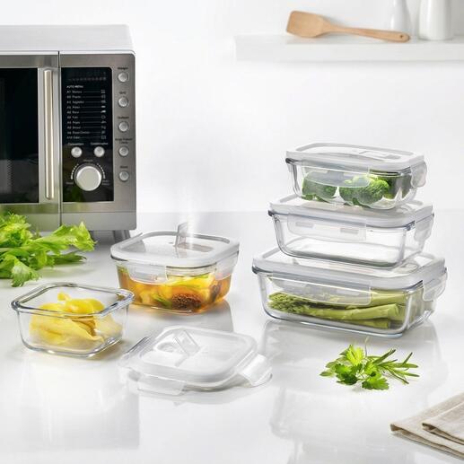Set aus fünf Glas-Frischeboxen mit Gemüse im Hintergrund.