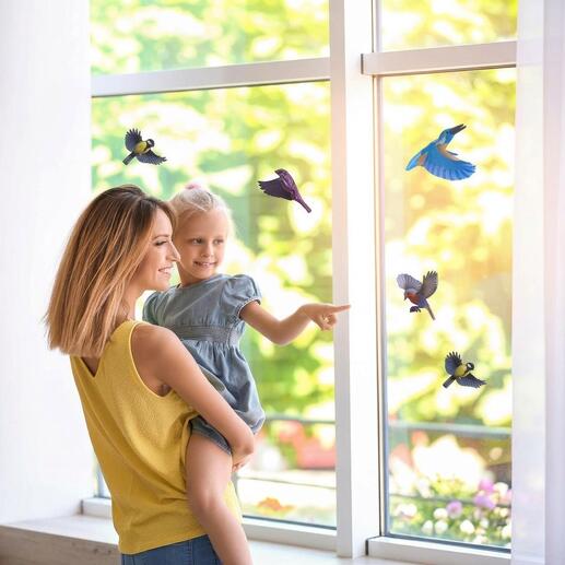Mutter mit Kind vor einem Fenster mit Vogelaufklebern