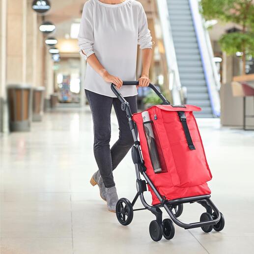 Frau schiebt einen roten Einkaufswagen Go up Premium in einem modernen Raum.