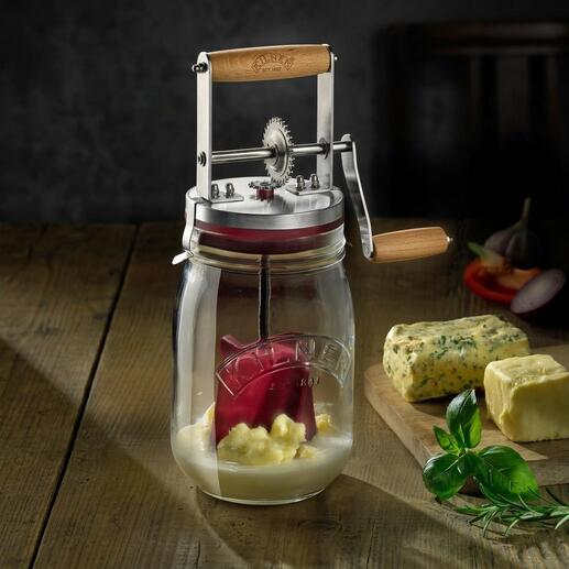 Butterglas mit Handkurbel auf einem Holztisch mit Butter