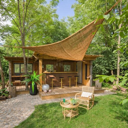 Sonnensegel aus Kokosfasern über einer Holzterrasse mit Barstühlen.