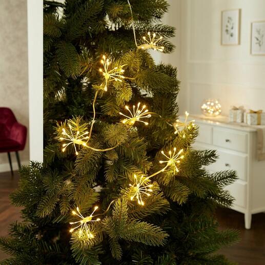 Lichterkette mit goldenen Lichtern, die wie Wunderkerzen auf einem Weihnachtsbaum wirken.