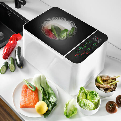 Food Washer Gerät auf Arbeitsplatte, umgeben von frischem Gemüse.