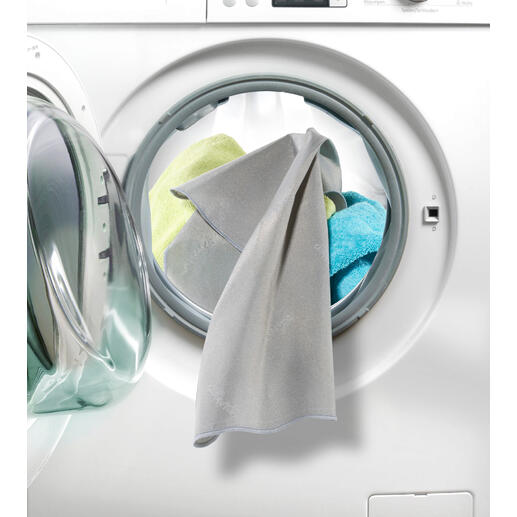 Aktivsilber beseitigt bis zu 99,9 % Bakterien auf Ihrer Wäsche. SilverWash®-Waschmaschinentuch hängt aus einer Waschmaschine mit bunten Tüchern