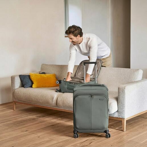 Mann packt einen leichten Travelite Trolley auf ein Sofa.