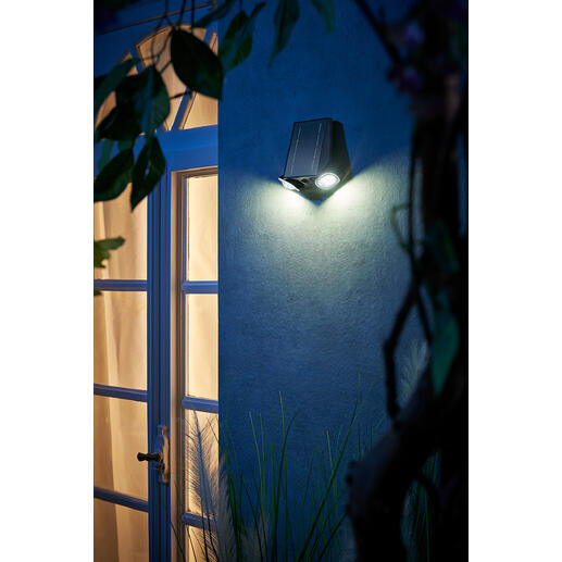 Intelligente Solarleuchte an einer Wand neben einer Tür bei Nacht