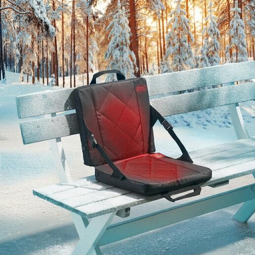 Beheizbare Sitzschale auf einer gefrorenen Parkbank im Winter.