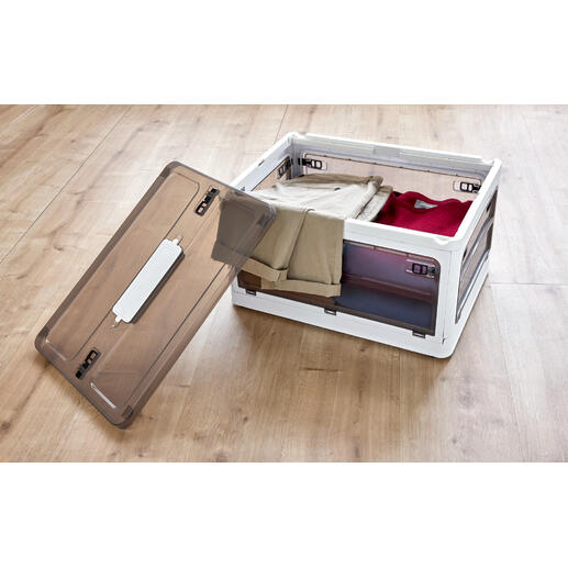 Offene Aufbewahrungsbox mit Kleidung auf Holzfußboden.