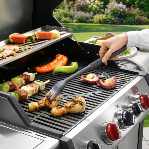 Grillpinsel in Aktion, um Fleisch auf dem Grill aufzutragen.