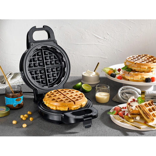 Extra tiefes Waffeleisen mit frischen Waffeln und Zutaten auf einem Tisch.
