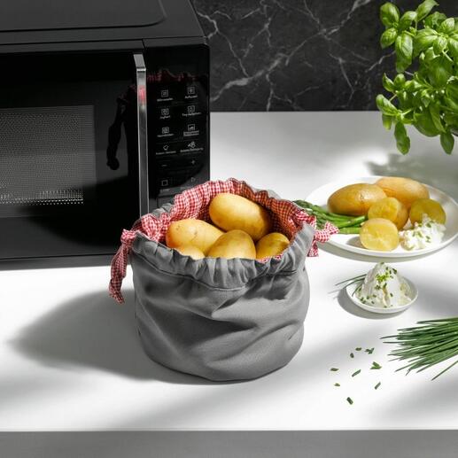 Grauer Kartoffel Garbeutel mit Kartoffeln und Kräutern auf dem Tisch.