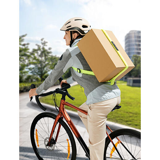 Mann auf Fahrrad mit Paketrucksack, der ein großes Paket transportiert.