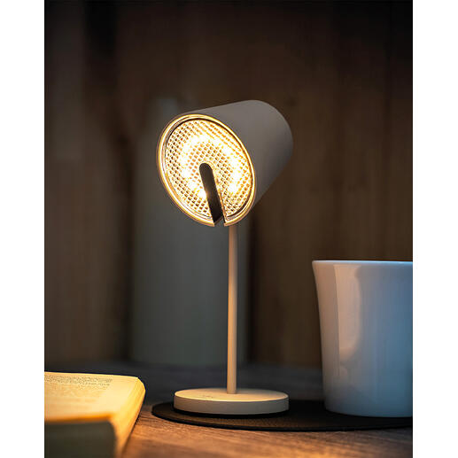 Schwarze Magnetleuchte mit hellem Licht, steht auf einem Tisch neben einer Tasse.