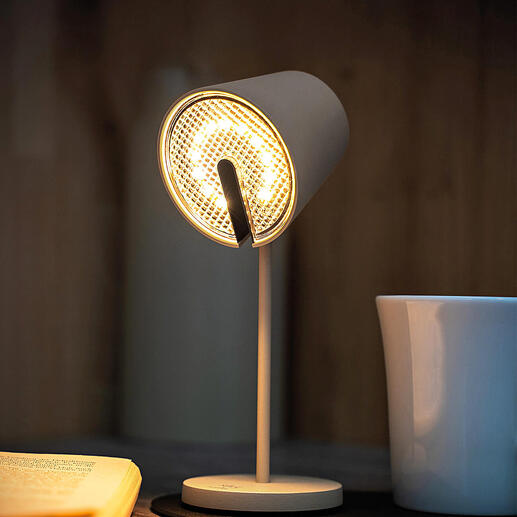 Schwarze Magnetleuchte mit hellem Licht, steht auf einem Tisch neben einer Tasse.
