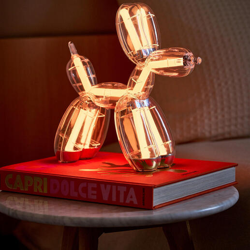 Ballonhund-Lampe auf einem Buch, warm-weiß leuchtend.
