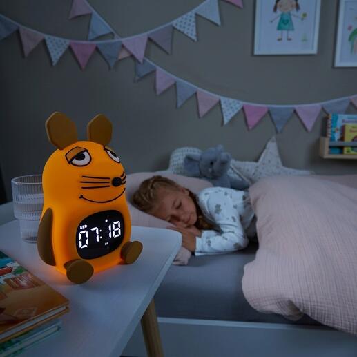 DieMaus Lichtwecker für Kinder auf einem Nachttisch neben schlafendem Mädchen.