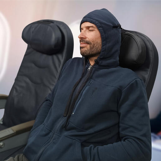Mann in Reise-Hoodie sitzt entspannt im Flugzeug mit Kapuze über dem Kopf.