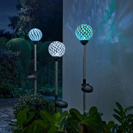 Drei Solargartenstecker mit bunten Mosaiklampen im Garten.