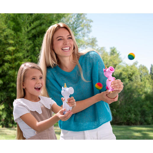 Frau und Mädchen lachen beim Spielen mit Einhorn-Ploppern im Freien.