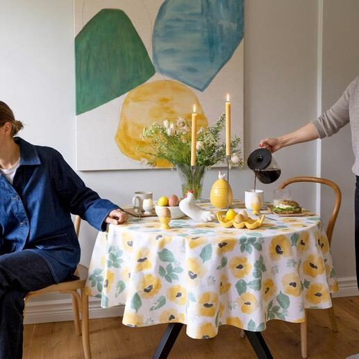Tisch mit Aquarell-Tischdecke und gedecktem Frühstück.