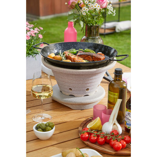 Bratfeuer mit Gemüse und Fisch auf einem Tisch im Freien.