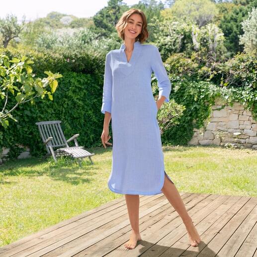 Frau in blauem Leinen-Tunika-Kleid, steht im Garten