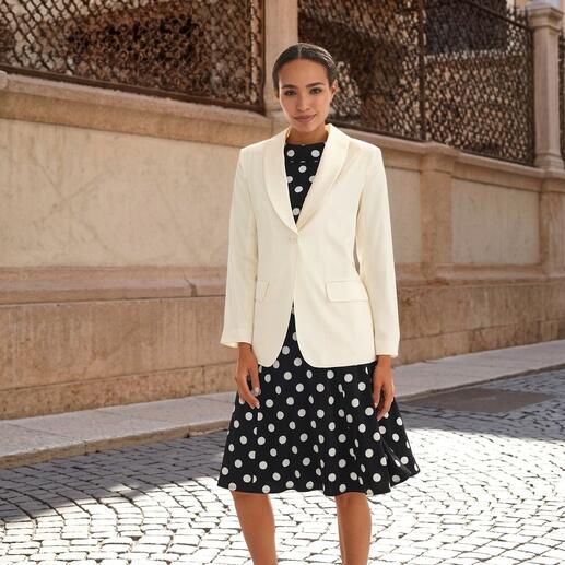 Weißer Seidenblazer über einem gepunkteten Kleid, eleganter Look.