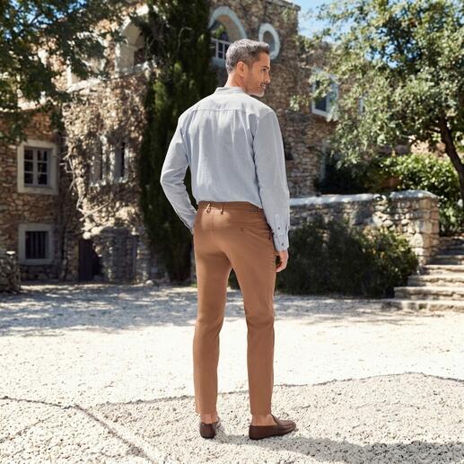 Mann in braunen Chinos von hinten, im Freien.