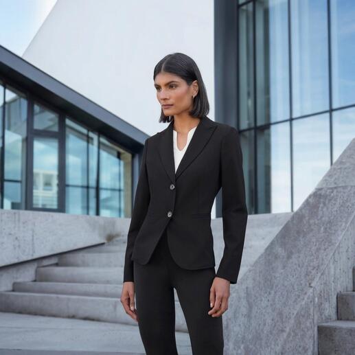 Frau in eleganter Blazer-Kombination vor modernen Gebäuden