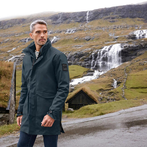 Mann in 3-in-1-Allwetter-Parka in einer Berglandschaft.