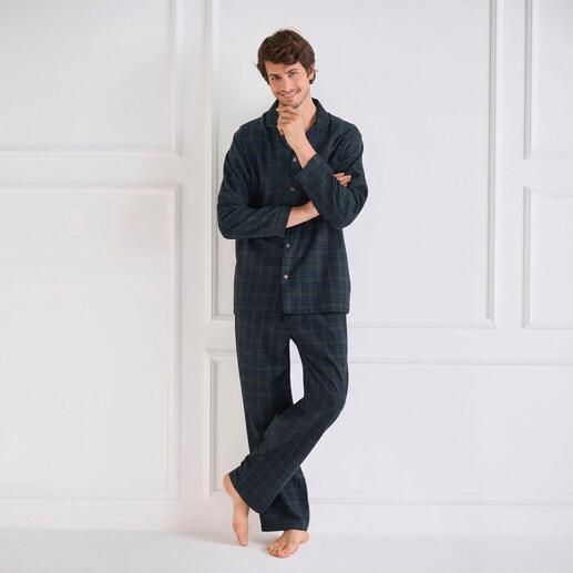 Mann in kariertem Flanellpyjama, steht mit verschränkten Armen.